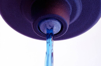 Close-up of a flow control valve on a purple closure for home care applications