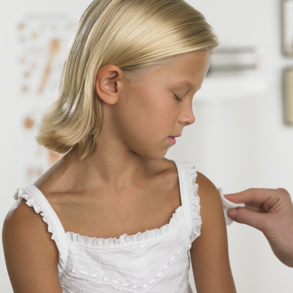 Young patient receives a vaccine or biologic injection in arm using Aptar Pharma’s advanced parenteral closures.