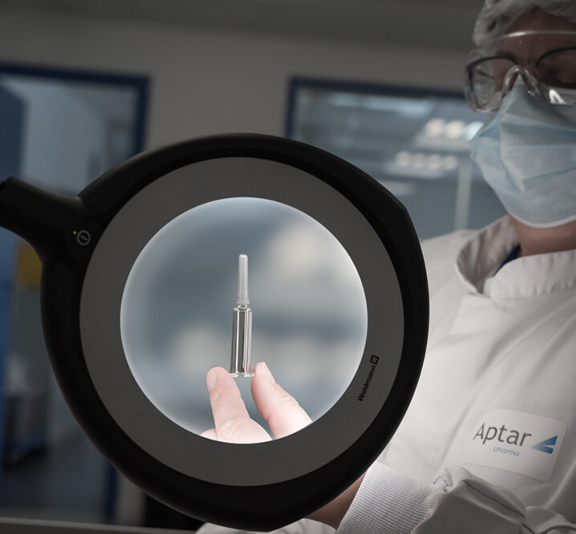 Aptar Pharma’s expert in rubber formulation and product design holding a pre-filled syringe with a needle shield