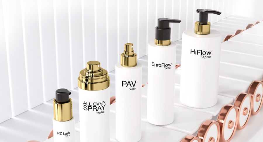 Five white packaging with metal effects golden dispensing systems and decorations standing on a conveyor belt on a white background