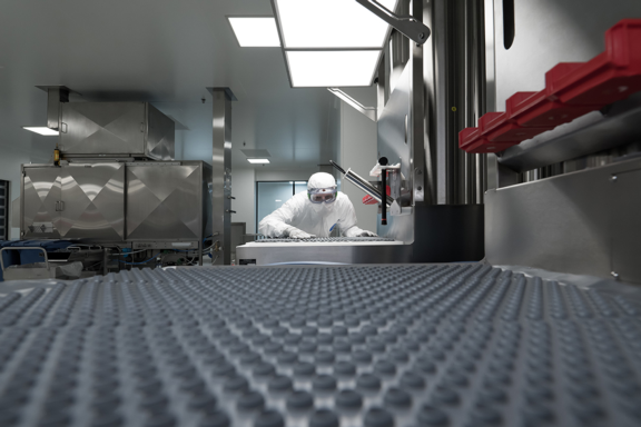 Aptar Pharma operator in a clean room for manufacturing Vial stoppers and limiting the risk of particulate or biological contamination